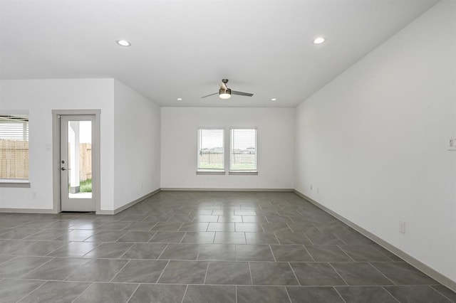 spare room featuring a ceiling fan, recessed lighting, dark tile patterned flooring, and baseboards