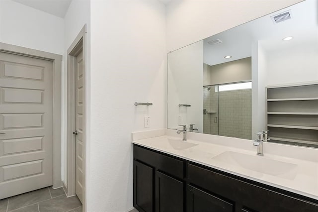 full bathroom featuring a stall shower, tile patterned flooring, a sink, and visible vents