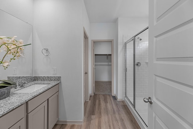 6605 Alexis St, Beaumont, TX 77708 - full bathroom with vanity, wood finished floors, a shower stall, and a spacious closet