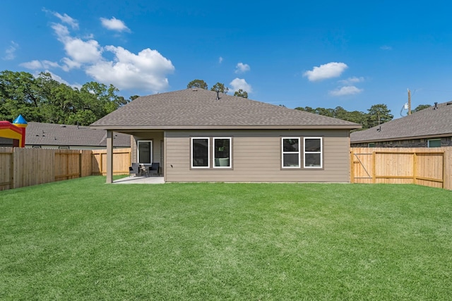 6605 Alexis St, Beaumont, TX 77708 - rear view of house with a lawn, a patio, a shingled roof, and a fenced backyard