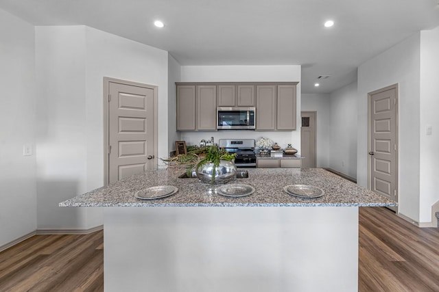6605 Alexis St, Beaumont, TX 77708 - kitchen with stainless steel appliances, wood finished floors, light stone counters, gray cabinetry, and baseboards