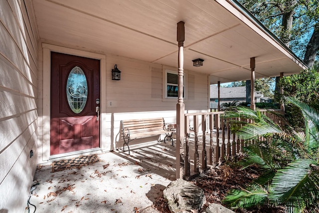 view of exterior entry featuring covered porch