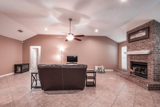 tiled living room featuring ceiling fan, a fireplace, and vaulted ceiling