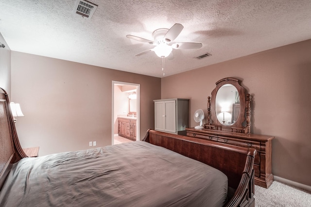 carpeted bedroom featuring ceiling fan, ensuite bathroom, and a textured ceiling