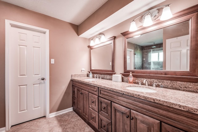 bathroom featuring tile patterned flooring, vanity, and tiled shower