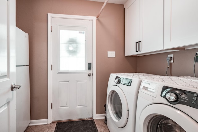 laundry area with washer and clothes dryer, cabinets, and light tile patterned floors