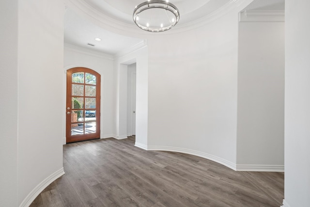 interior space with hardwood / wood-style flooring, crown molding, and an inviting chandelier