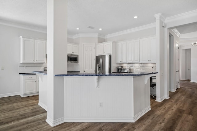 kitchen featuring decorative backsplash, appliances with stainless steel finishes, dark hardwood / wood-style flooring, and white cabinetry