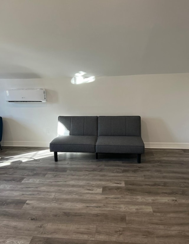 sitting room with a wall mounted air conditioner and dark wood-type flooring