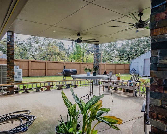 view of patio with ceiling fan, a grill, a storage unit, and central AC