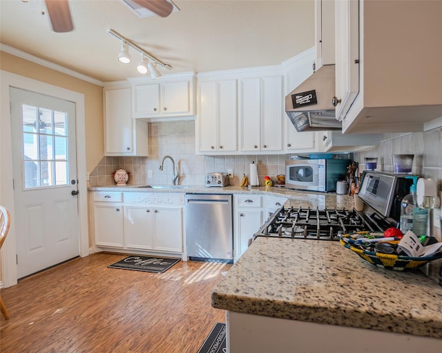 kitchen featuring light stone counters, appliances with stainless steel finishes, ceiling fan, and white cabinetry