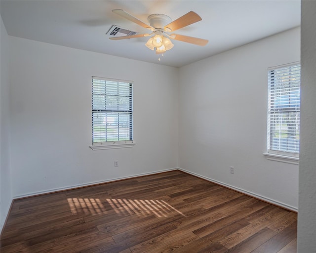 empty room featuring dark hardwood / wood-style flooring, ceiling fan, and a healthy amount of sunlight