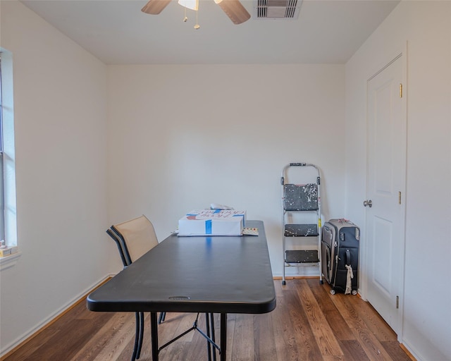 dining area with dark wood-type flooring and ceiling fan