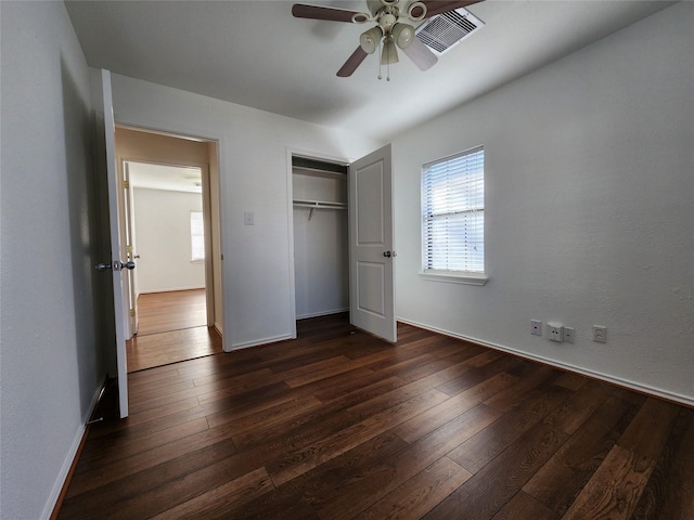 unfurnished bedroom with dark hardwood / wood-style flooring, a closet, and ceiling fan