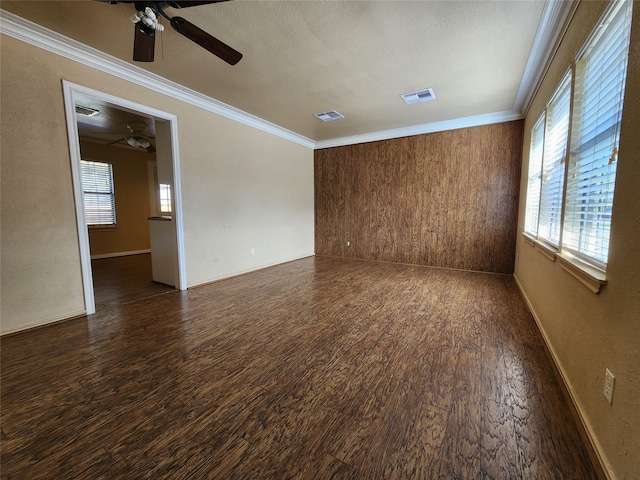 spare room featuring crown molding and dark hardwood / wood-style flooring