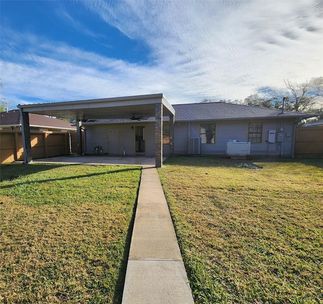 rear view of house featuring central AC, a yard, and a carport