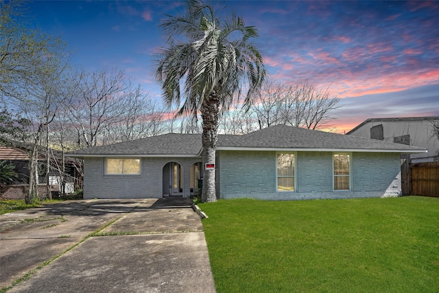 ranch-style home with a lawn