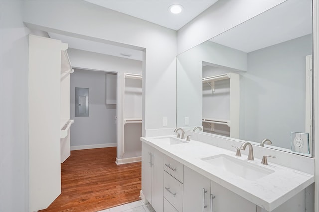 bathroom featuring hardwood / wood-style floors, vanity, and electric panel