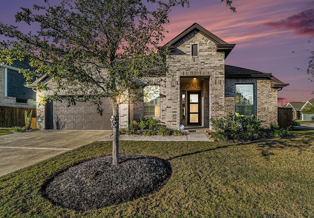 view of front of property featuring a garage and a yard