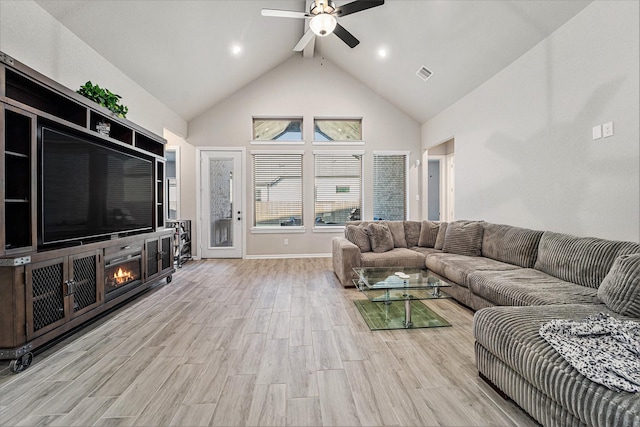 living room featuring ceiling fan, light hardwood / wood-style flooring, and high vaulted ceiling