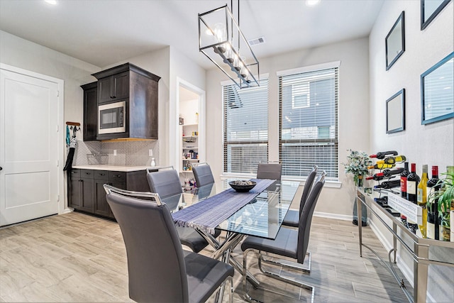 dining area with a chandelier and light wood-type flooring