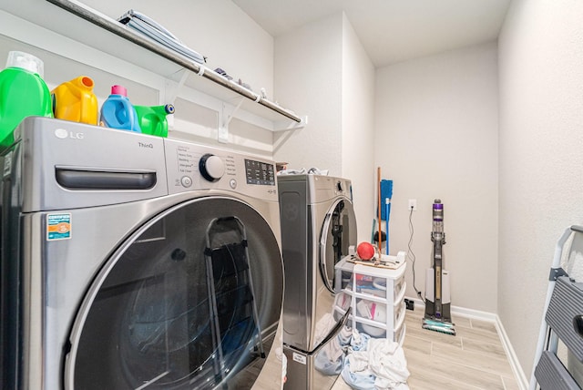 washroom with washer and dryer and light wood-type flooring