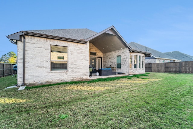 rear view of property featuring a yard, an outdoor living space, and a patio