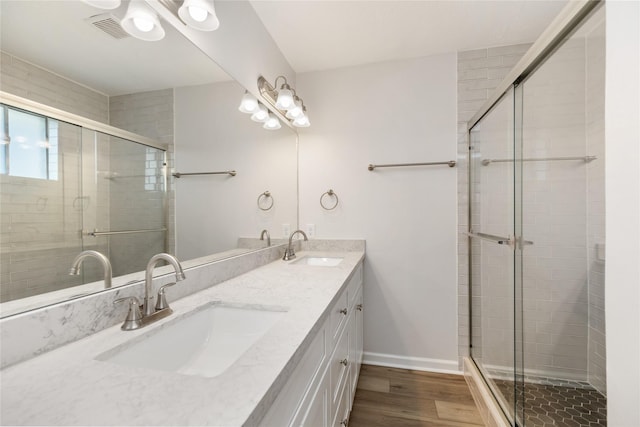 bathroom with vanity, wood-type flooring, and a shower with door