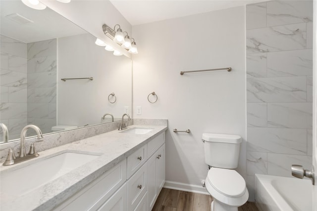 bathroom with vanity, toilet, and wood-type flooring