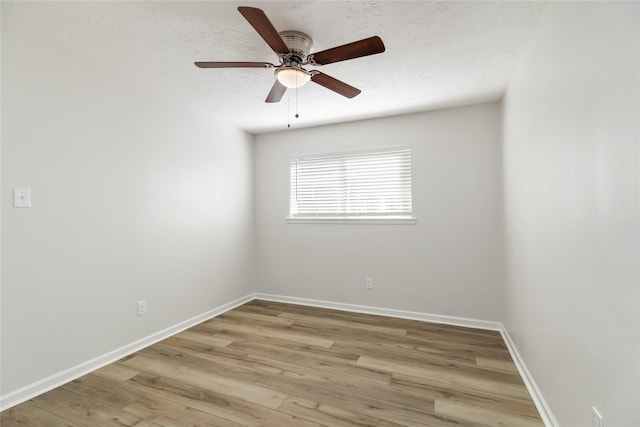 unfurnished room with a textured ceiling, light wood-type flooring, and ceiling fan