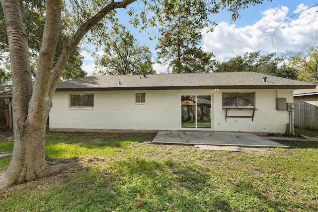 back of property featuring a lawn and a patio