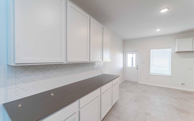 kitchen featuring backsplash and white cabinets