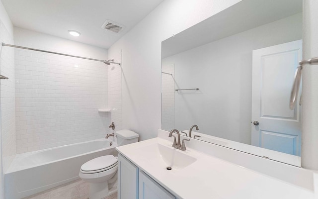 full bathroom with tiled shower / bath, vanity, and toilet