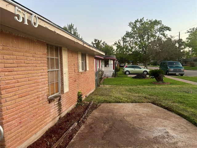 view of side of property featuring a yard and a patio