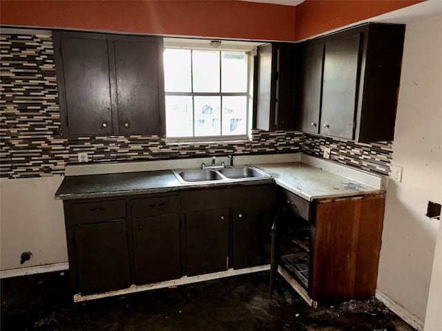 kitchen featuring decorative backsplash, dark brown cabinetry, and sink