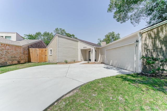 exterior space featuring a garage and a lawn