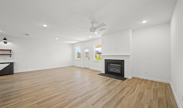 unfurnished living room featuring ceiling fan and light hardwood / wood-style flooring