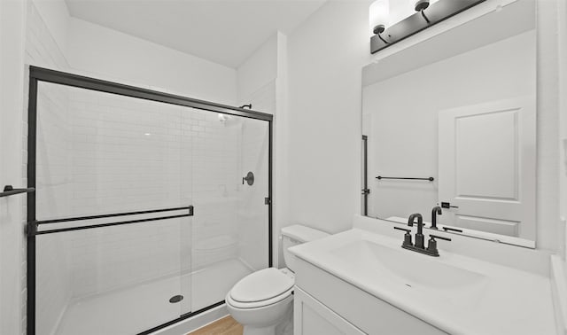 bathroom featuring hardwood / wood-style floors, toilet, walk in shower, and vanity