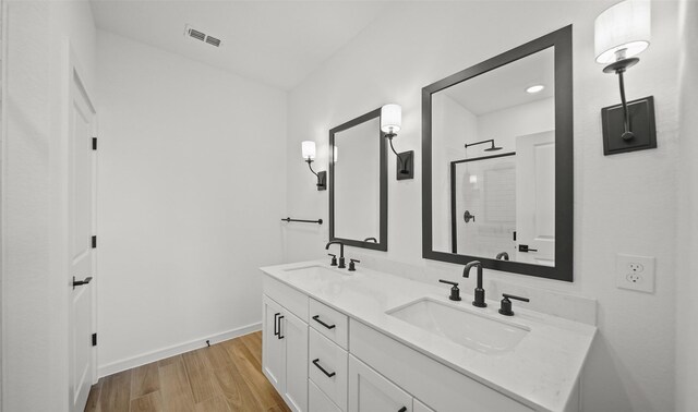 bathroom featuring a shower with shower door, wood-type flooring, and vanity