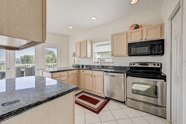 kitchen with kitchen peninsula, appliances with stainless steel finishes, a healthy amount of sunlight, and sink