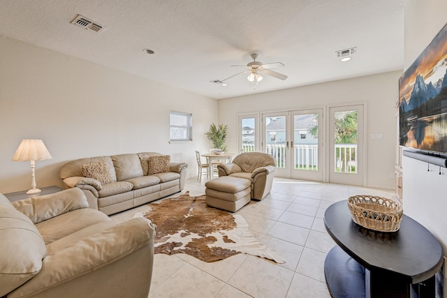 tiled living room with a textured ceiling and ceiling fan