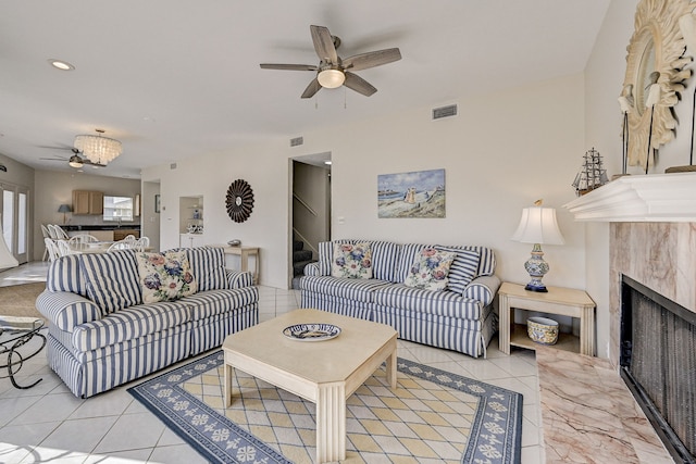 tiled living room featuring a fireplace and ceiling fan