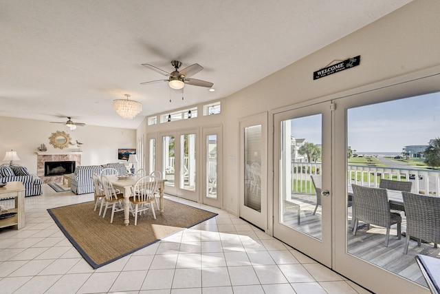 tiled dining room featuring a tile fireplace, french doors, and a wealth of natural light