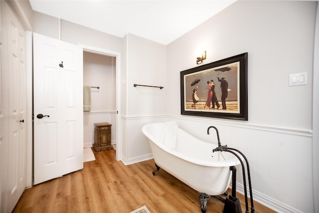 bathroom with a washtub and hardwood / wood-style floors