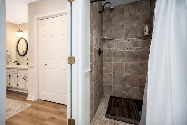 bathroom featuring hardwood / wood-style floors, vanity, and walk in shower