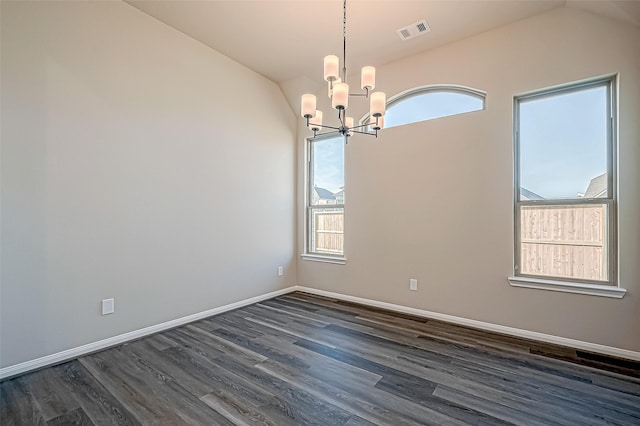 spare room with plenty of natural light, dark hardwood / wood-style flooring, and vaulted ceiling