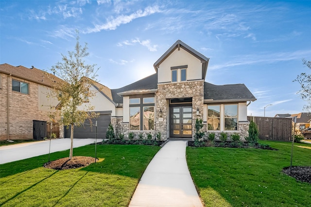 view of front of property with french doors, a garage, and a front lawn