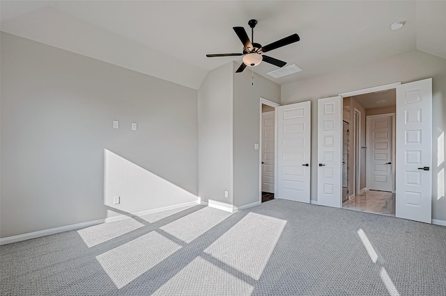 unfurnished bedroom with light colored carpet, vaulted ceiling, and ceiling fan