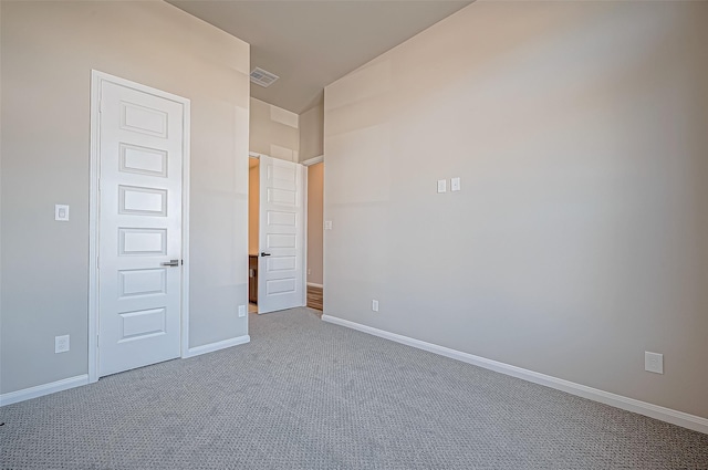 unfurnished bedroom with carpet floors and vaulted ceiling