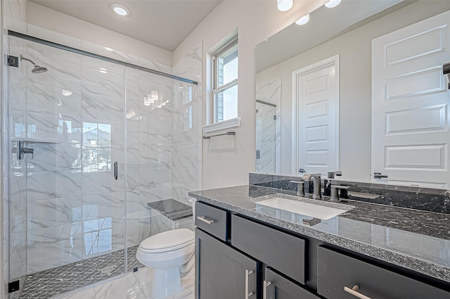 bathroom with vanity, a shower with shower door, and toilet